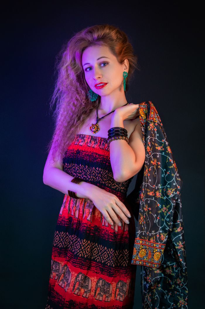 Crafting Captivating Headlines: Your awesome post title goes here Woman posing in vibrant bohemian dress with patterned shawl, studio lighting.