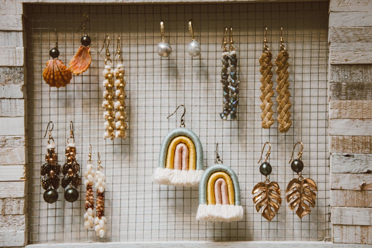 Mastering the First Impression: Your intriguing post title goes here A stylish collection of handmade earrings displayed in a rustic wooden frame with a grid backdrop.